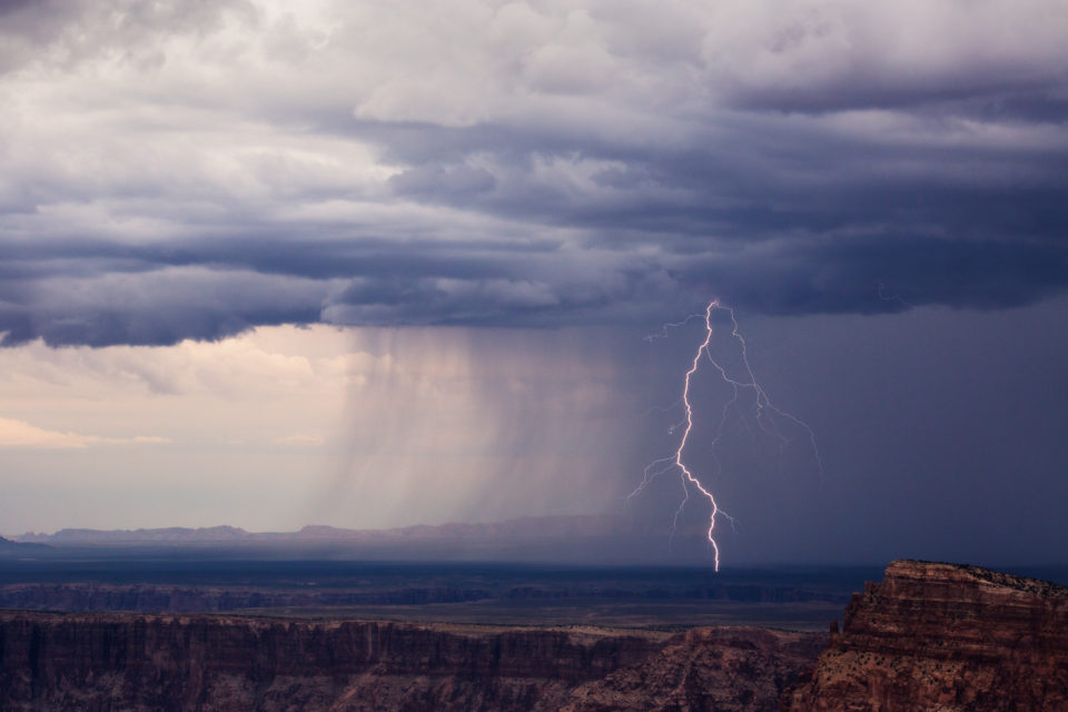 A bolt from a summer thunderstorm drops just on the north side of the Little Colorad River as seen from the Grand Canyon's Navajo Point.